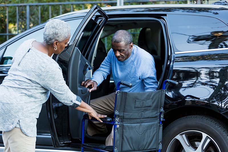 getting out of the car into a transport chair