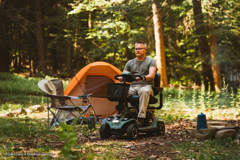 man on a mobility scooter in the wilderness at a campsite