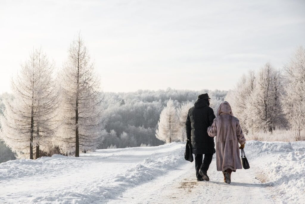 couple walking in the snow bundled up